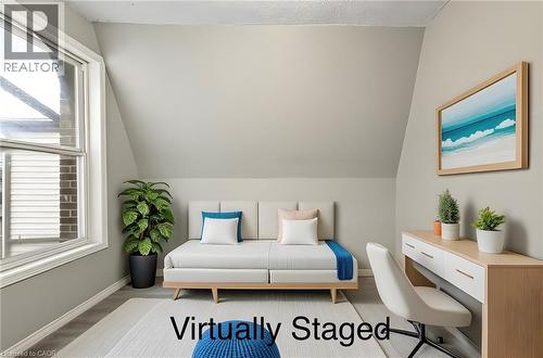 This room features a window providing natural light, sloped ceilings, and light-colored walls - 23 Frederick Avenue, Hamilton, ON - Indoor Photo Showing Bedroom