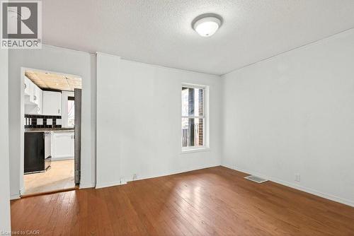 Empty room featuring light wood-type flooring and a textured ceiling - 23 Frederick Avenue, Hamilton, ON - Indoor Photo Showing Other Room