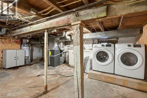 Unfinished below grade area featuring heating unit, gas water heater, and washer and clothes dryer - 23 Frederick Avenue, Hamilton, ON - Indoor Photo Showing Laundry Room