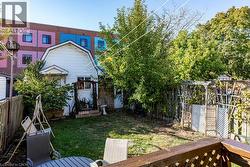 Rear view of house featuring a fenced backyard and a gambrel roof - 