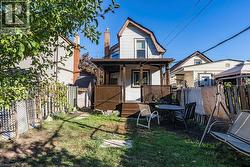 Rear view of house featuring a fenced backyard, a gambrel roof, and a storage shed - 