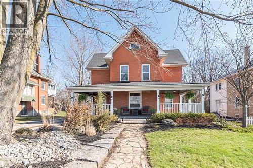 View of front of property featuring brick siding, a porch, and a front yard - 120 Caithness Street E, Caledonia, ON - Outdoor With Deck Patio Veranda