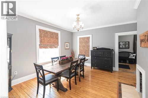 Dining area featuring light wood-style flooring, ornamental molding, and hanging lights - 120 Caithness Street E, Caledonia, ON - Indoor Photo Showing Dining Room