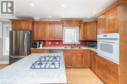 Kitchen featuring stainless steel appliances, light countertops, wood finish cabinetry, light wood-style floors, and recessed lighting - 120 Caithness Street E, Caledonia, ON - Indoor Photo Showing Kitchen With Double Sink