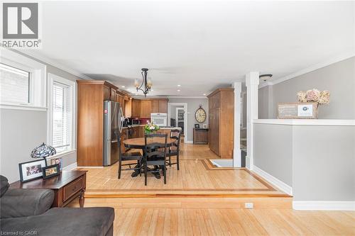 Dining area featuring light wood-type flooring, crown molding, and hanging lights - 120 Caithness Street E, Caledonia, ON - Indoor