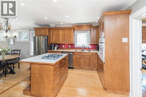 Kitchen featuring light countertops, stainless steel appliances, light wood-style flooring, a kitchen island, and wood finish cabinets - 120 Caithness Street E, Caledonia, ON - Indoor Photo Showing Kitchen With Double Sink