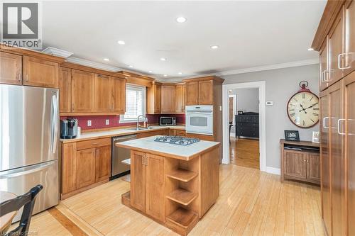 Kitchen featuring light countertops, stainless steel appliances, wood finish cabinets, ornamental molding, and recessed lighting - 120 Caithness Street E, Caledonia, ON - Indoor Photo Showing Kitchen