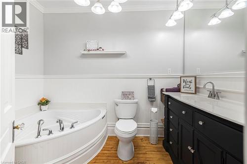 Full bathroom featuring crown molding, vanity, a garden tub, wood finished floors, and wainscoting - 120 Caithness Street E, Caledonia, ON - Indoor Photo Showing Bathroom