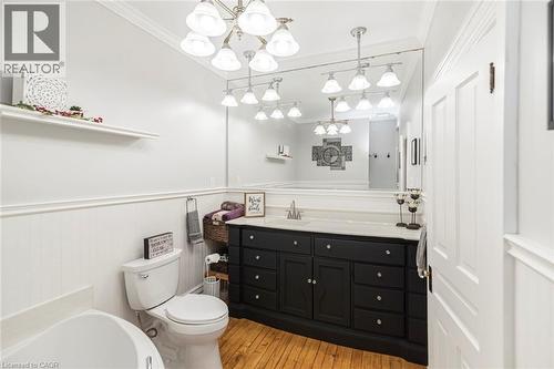 Full bathroom featuring vanity, a wainscoted wall, crown molding, a garden tub, and light wood-style flooring - 120 Caithness Street E, Caledonia, ON - Indoor Photo Showing Bathroom