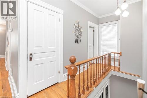 Hall featuring ornamental molding, an upstairs landing, and light wood-style floors - 120 Caithness Street E, Caledonia, ON - Indoor Photo Showing Other Room