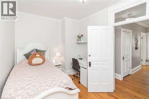 Bedroom with ornamental molding, light wood-style floors, and built in desk - 120 Caithness Street E, Caledonia, ON - Indoor Photo Showing Bedroom