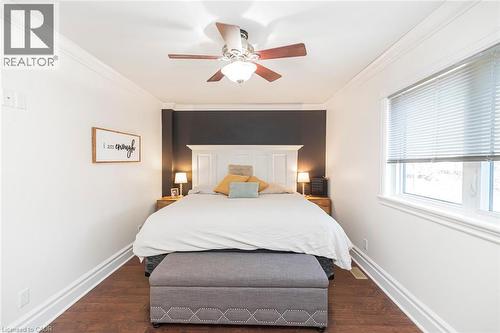 Bedroom featuring dark wood-style floors, ornamental molding, and ceiling fan - 120 Caithness Street E, Caledonia, ON - Indoor Photo Showing Bedroom