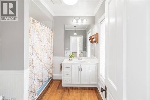 Full bathroom featuring wainscoting, crown molding, vanity, light wood finished floors, and a shower with curtain - 120 Caithness Street E, Caledonia, ON - Indoor Photo Showing Bathroom