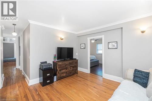 Living room with ornamental molding and light wood-style floors - 120 Caithness Street E, Caledonia, ON - Indoor