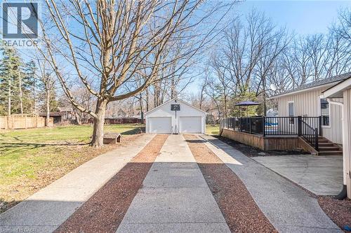 View of yard with a wooden deck, a detached garage, and an outdoor structure - 120 Caithness Street E, Caledonia, ON - Outdoor