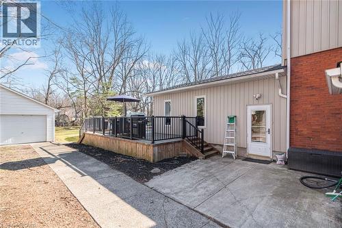 Back of property featuring a deck, a garage, board and batten siding, and a patio area - 120 Caithness Street E, Caledonia, ON - Outdoor With Deck Patio Veranda