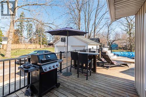 Wooden deck featuring an outbuilding, a grill, a pool, and a detached garage - 120 Caithness Street E, Caledonia, ON - Outdoor With Deck Patio Veranda
