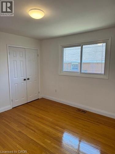 Unfurnished bedroom featuring light wood-style flooring and a closet - 31 Adair Avenue, Hamilton, ON - Indoor Photo Showing Other Room