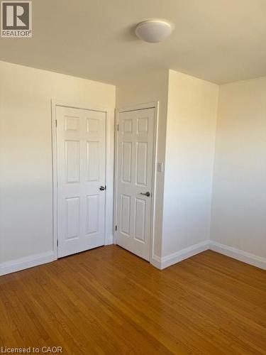 Unfurnished bedroom with wood finished floors and baseboards - 31 Adair Avenue, Hamilton, ON - Indoor Photo Showing Other Room