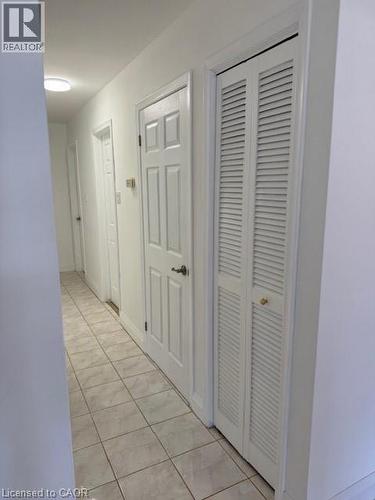 Hallway with light tile patterned floors and baseboards - 31 Adair Avenue, Hamilton, ON - Indoor Photo Showing Other Room