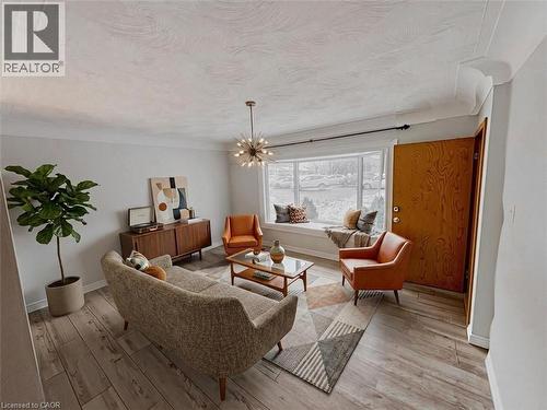 Living area featuring a chandelier and light wood-style flooring. Virtually staged. - 122 Weber Street S, Waterloo, ON - Indoor Photo Showing Other Room