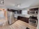 Kitchen featuring rail lighting, stainless steel appliances, dark wood finish cabinets, light countertops, and light wood finished floors - 122 Weber Street S, Waterloo, ON  - Indoor Photo Showing Kitchen 