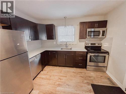 Kitchen featuring stainless steel appliances, dark wood finish cabinetry, and light countertops - 122 Weber Street S, Waterloo, ON - Indoor Photo Showing Kitchen