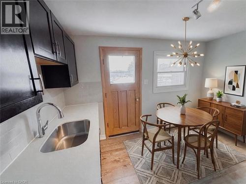 Dining space featuring light wood-style floors and hanging lights. 2nd level kitchen. Virtually staged. - 122 Weber Street S, Waterloo, ON - Indoor Photo Showing Other Room