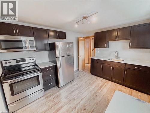 Kitchen featuring stainless steel appliances, dark wood finish cabinetry, and light countertops - 122 Weber Street S, Waterloo, ON - Indoor Photo Showing Kitchen