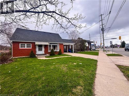 The property features a red brick exterior, a dark shingled roof, and a green lawn - 122 Weber Street S, Waterloo, ON - Outdoor