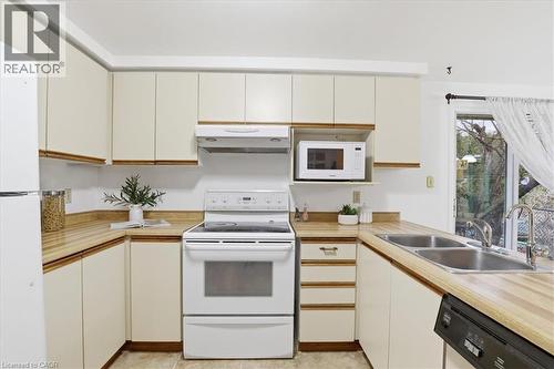 Kitchen featuring white appliances and light countertops - 56 Rushbrook Drive, Kitchener, ON - Indoor Photo Showing Kitchen With Double Sink