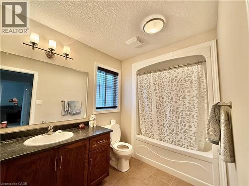 Bathroom featuring vanity, shower / bathtub combination with curtain, light tile patterned flooring, and a textured ceiling - 101 Robert Simone Way, Ayr, ON - Indoor Photo Showing Bathroom