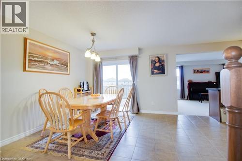 Tiled dining area featuring a notable chandelier - 101 Robert Simone Way, Ayr, ON - Indoor Photo Showing Dining Room
