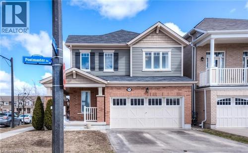 Craftsman inspired home featuring a porch, a garage, concrete driveway, and brick siding - 60 Postmaster Drive, Kitchener, ON - Outdoor With Facade