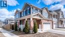 View of side of property with a garage, driveway, a porch, brick siding, and a residential view - 60 Postmaster Drive, Kitchener, ON  - Outdoor With Facade 
