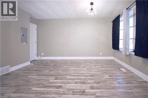 Unfurnished room featuring suspended lighting, light wood-style floors, and electric panel - 61 Bosworth Crescent Unit# Upper, Kitchener, ON - Indoor Photo Showing Other Room