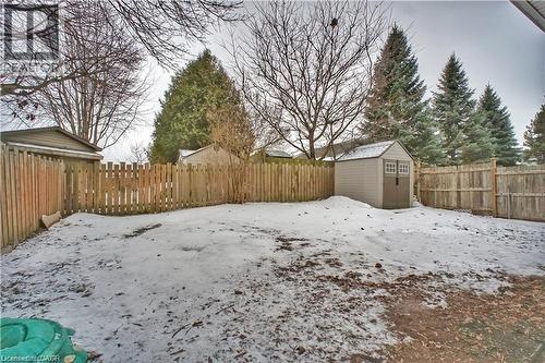Yard covered in snow with a storage shed and a fenced backyard - 61 Bosworth Crescent Unit# Upper, Kitchener, ON - Outdoor