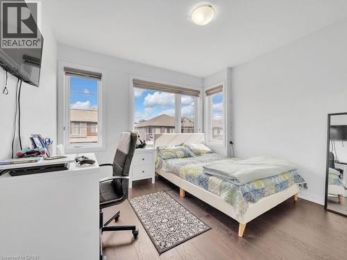 Bedroom featuring a desk, dark wood-type flooring, and multiple windows - 30 Times Square Boulevard, Hamilton, ON - Indoor Photo Showing Bedroom