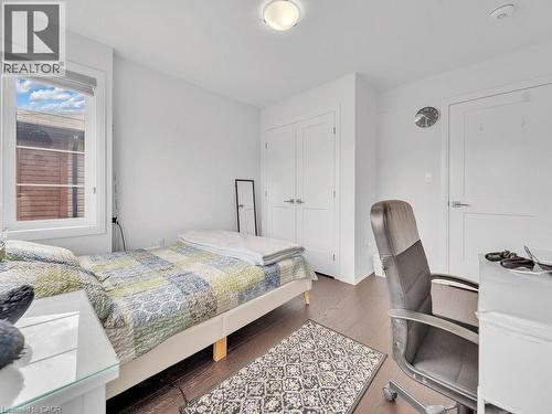 Bedroom with dark wood-type flooring, a closet, and an office area - 30 Times Square Boulevard, Hamilton, ON - Indoor Photo Showing Bedroom