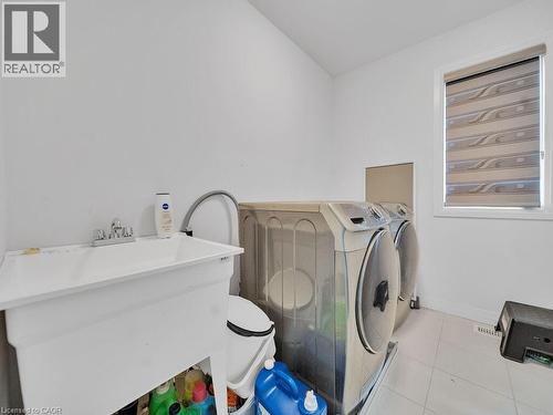 Laundry area featuring light tile patterned floors and washing machine and clothes dryer - 30 Times Square Boulevard, Hamilton, ON - Indoor Photo Showing Laundry Room