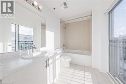 Full bath with vanity, light tile patterned floors, and bathtub / shower combination - 