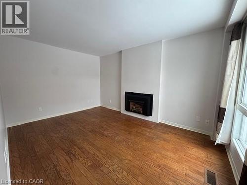 Unfurnished living room with dark wood-type flooring and a fireplace - 536 Thorndale Drive, Waterloo, ON - Indoor With Fireplace