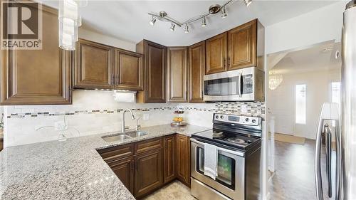 Kitchen with stainless steel appliances, light stone countertops, and decorative backsplash - 330 Guelph Avenue, Cambridge, ON - Indoor Photo Showing Kitchen With Double Sink With Upgraded Kitchen