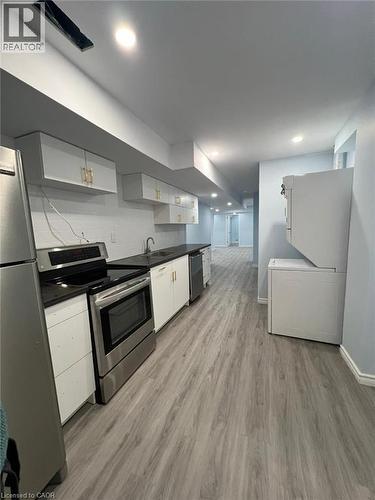 Kitchen featuring stainless steel appliances, white cabinetry, dark countertops, light wood-style flooring, and recessed lighting - 167 Histand Trail Unit# Lower, Kitchener, ON - Indoor Photo Showing Kitchen