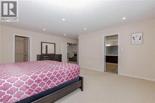 Bedroom with light colored carpet, a walk in closet, recessed lighting, and a textured ceiling - 2 Doon Creek Street, Kitchener, ON - Indoor Photo Showing Bedroom