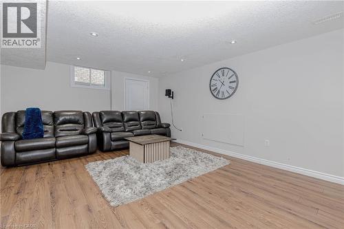 Living room with light wood-type flooring, a textured ceiling, and recessed lighting - 2 Doon Creek Street, Kitchener, ON - Indoor Photo Showing Other Room