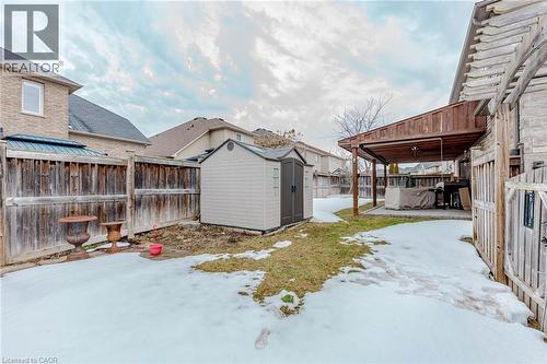 Yard covered in snow with a patio area, a storage shed, and a fenced backyard - 2 Doon Creek Street, Kitchener, ON - Outdoor