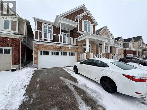 Craftsman-style home with a balcony, asphalt driveway, an attached garage, and brick siding - 31 Sofitel Drive, Kitchener, ON - Outdoor With Balcony With Facade