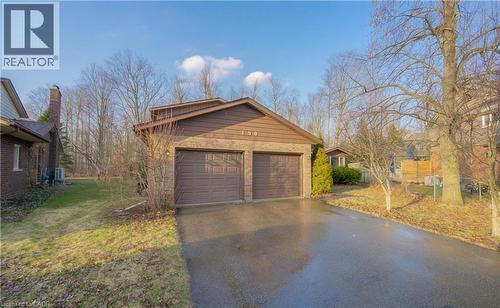 View of property exterior featuring an outdoor structure, brick siding, a detached garage, and a lawn - 190 Silvercrest Drive, Waterloo, ON - Outdoor