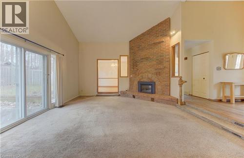 Unfurnished living room featuring lofted ceiling, carpet floors, and a brick fireplace - 190 Silvercrest Drive, Waterloo, ON - Indoor With Fireplace